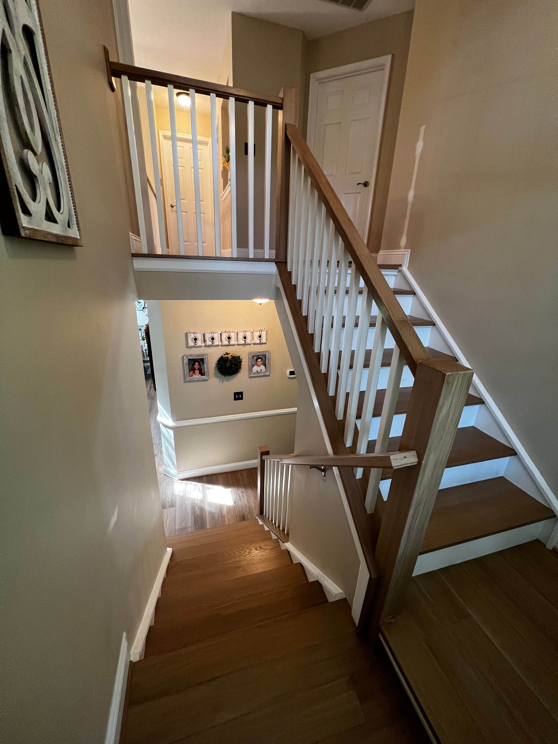 A wooden staircase with a white railing leading up to the second floor of a house.