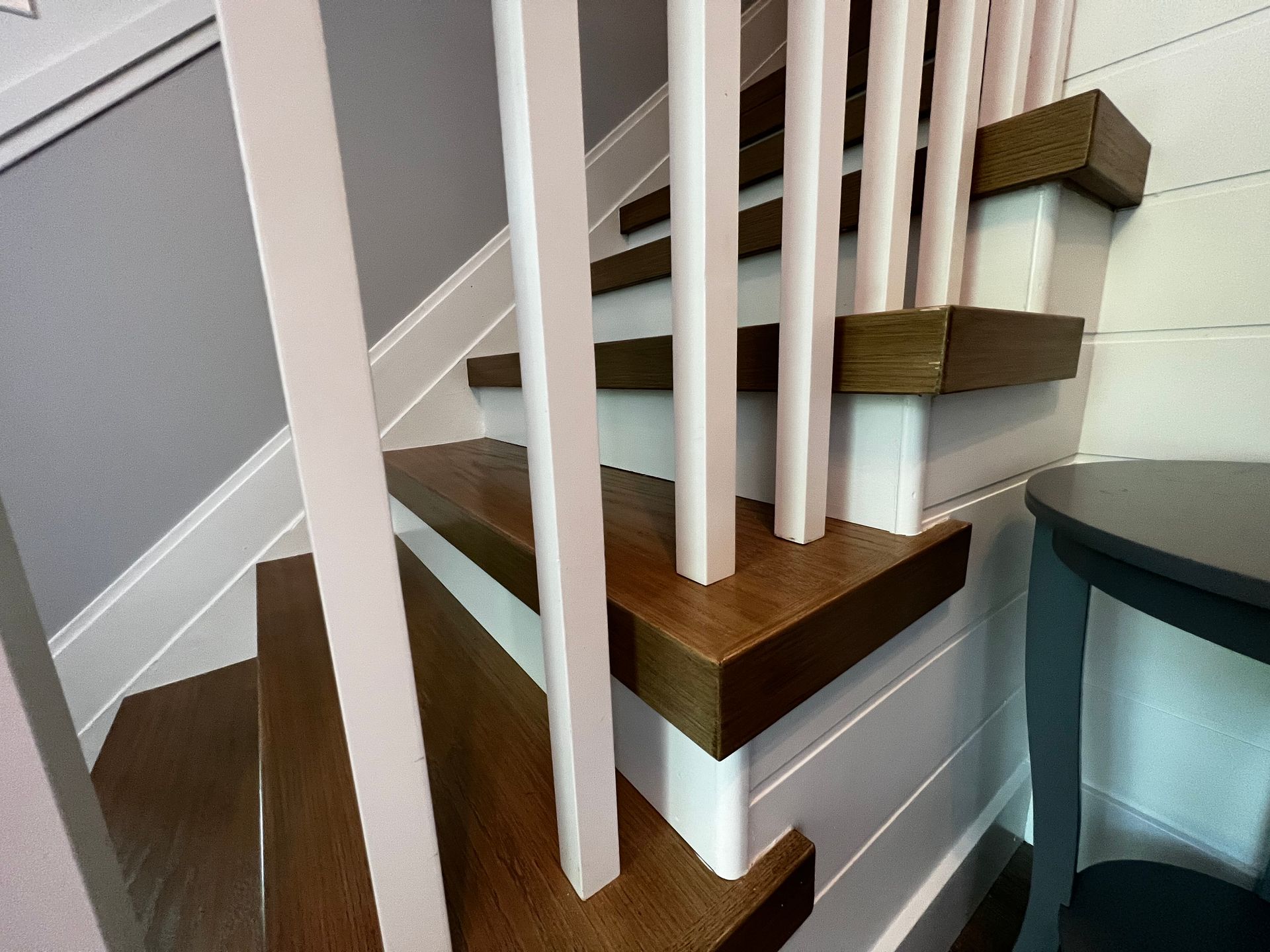 A close up of a wooden staircase with white railings