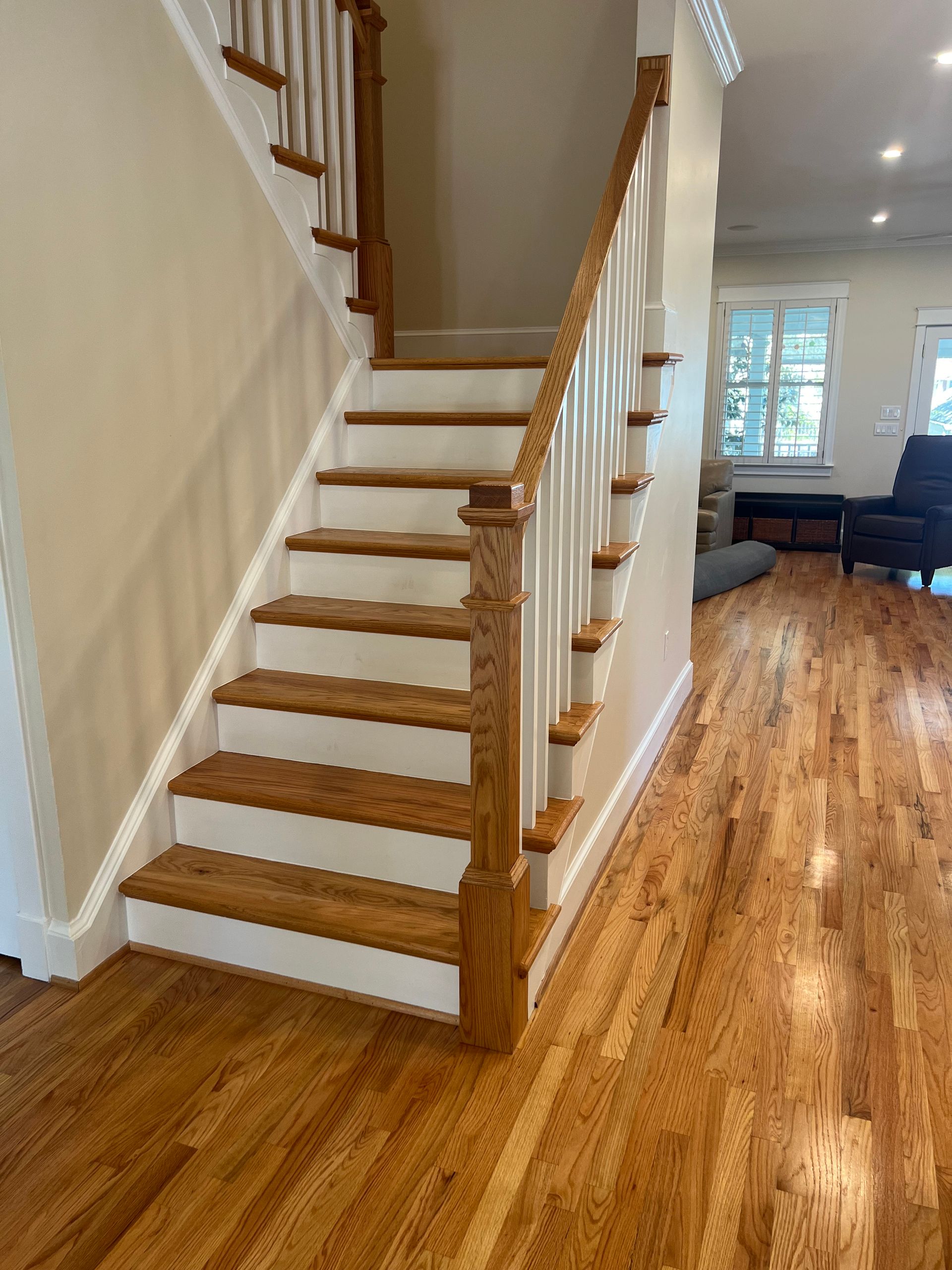 A staircase with wooden steps and a white railing in a living room.