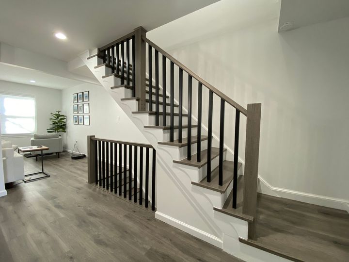 A staircase with a black railing is leading up to the second floor of a house.