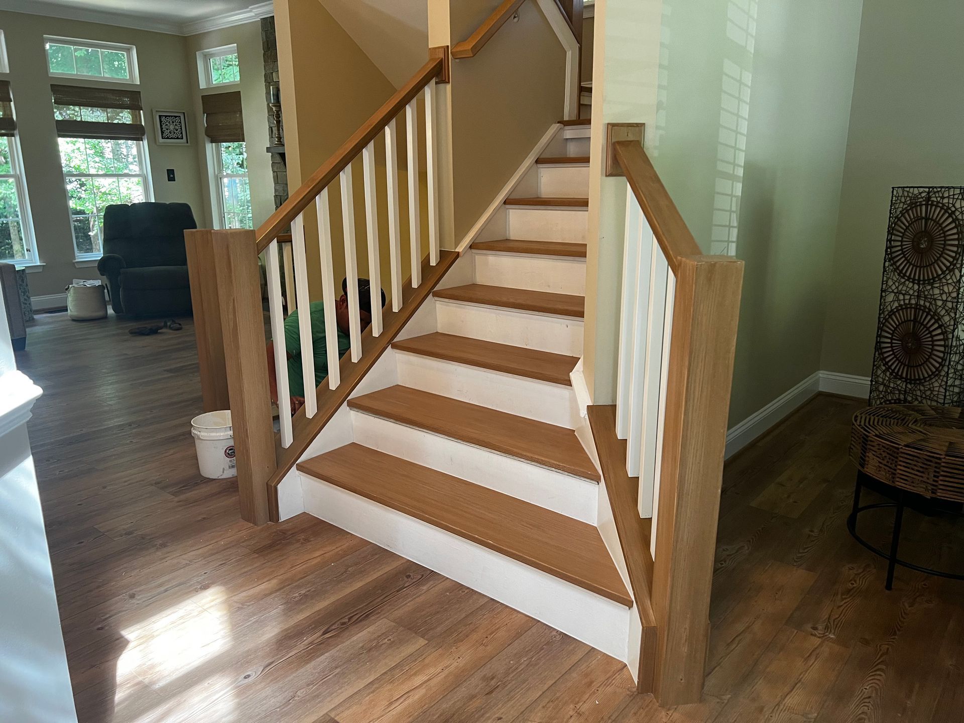 A wooden staircase with a white railing in a living room.
