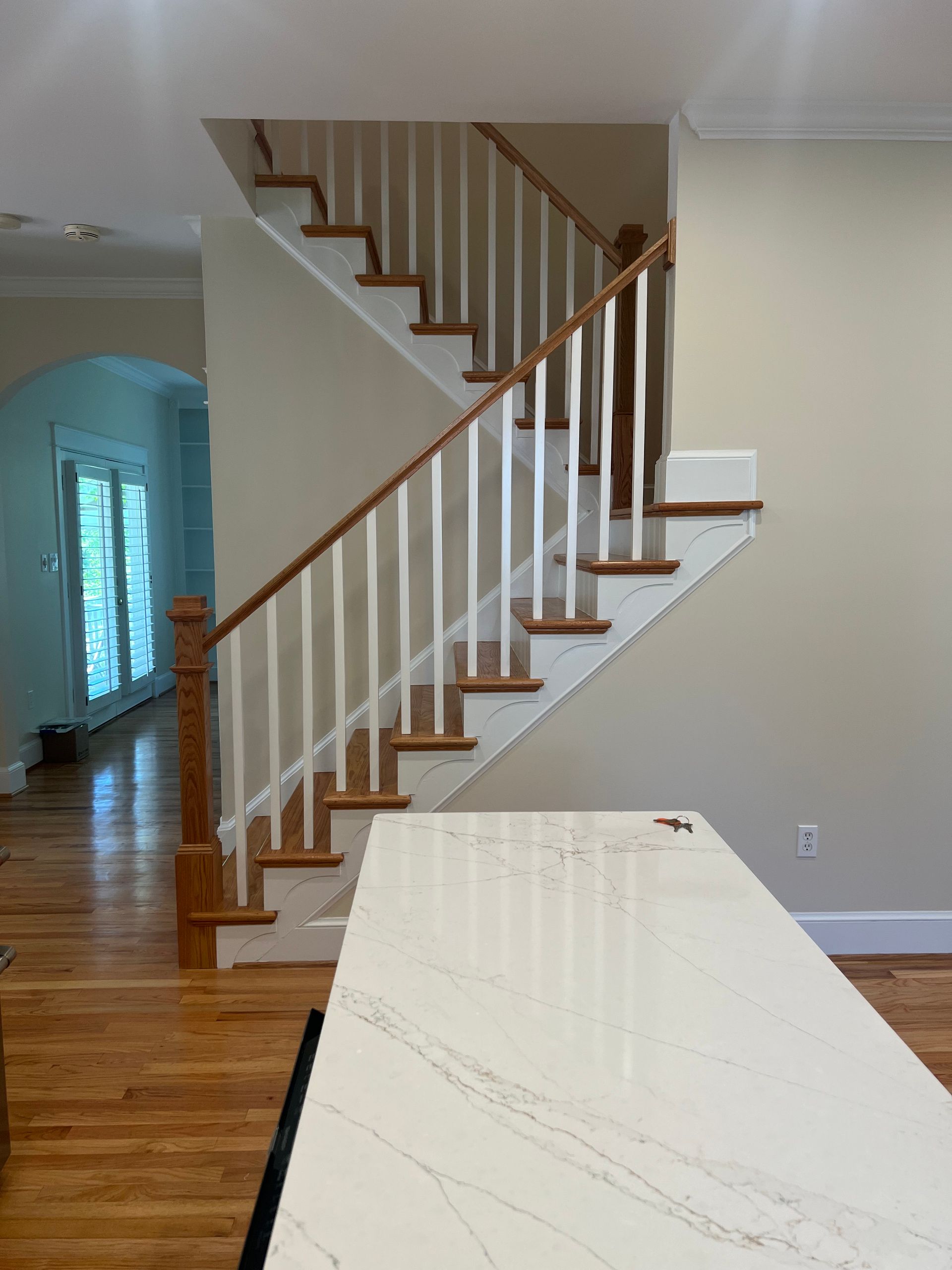 A staircase in a house with a white railing and wooden steps