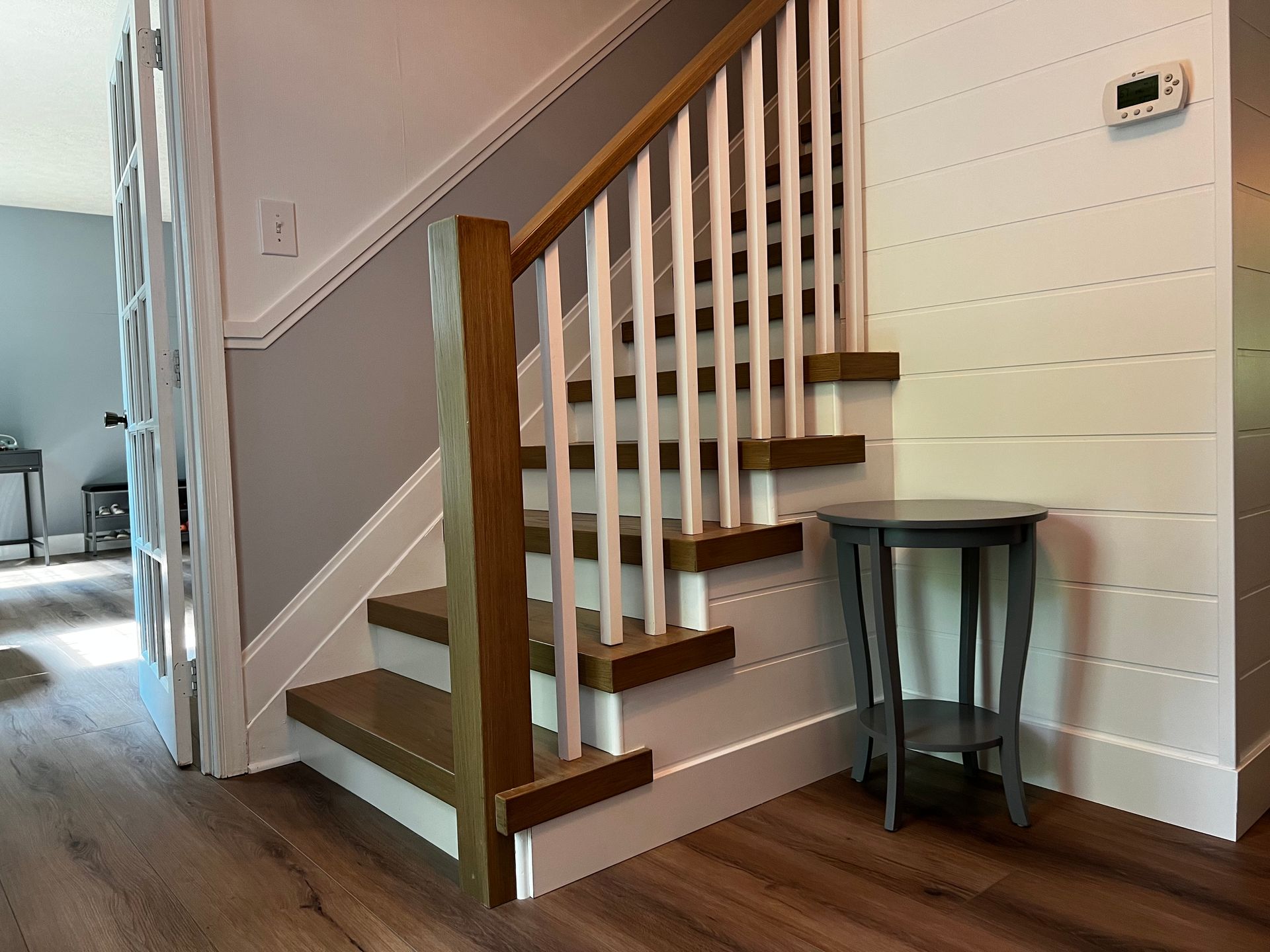 A staircase with wooden steps and white railings in a house.