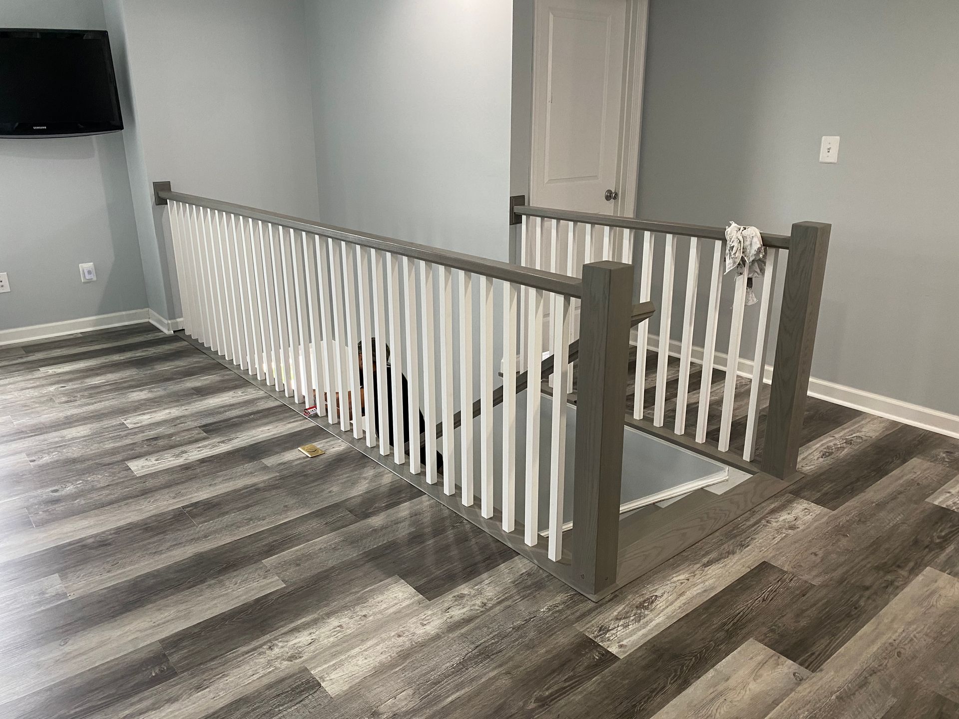 There is a staircase in the middle of the room with a wooden railing.