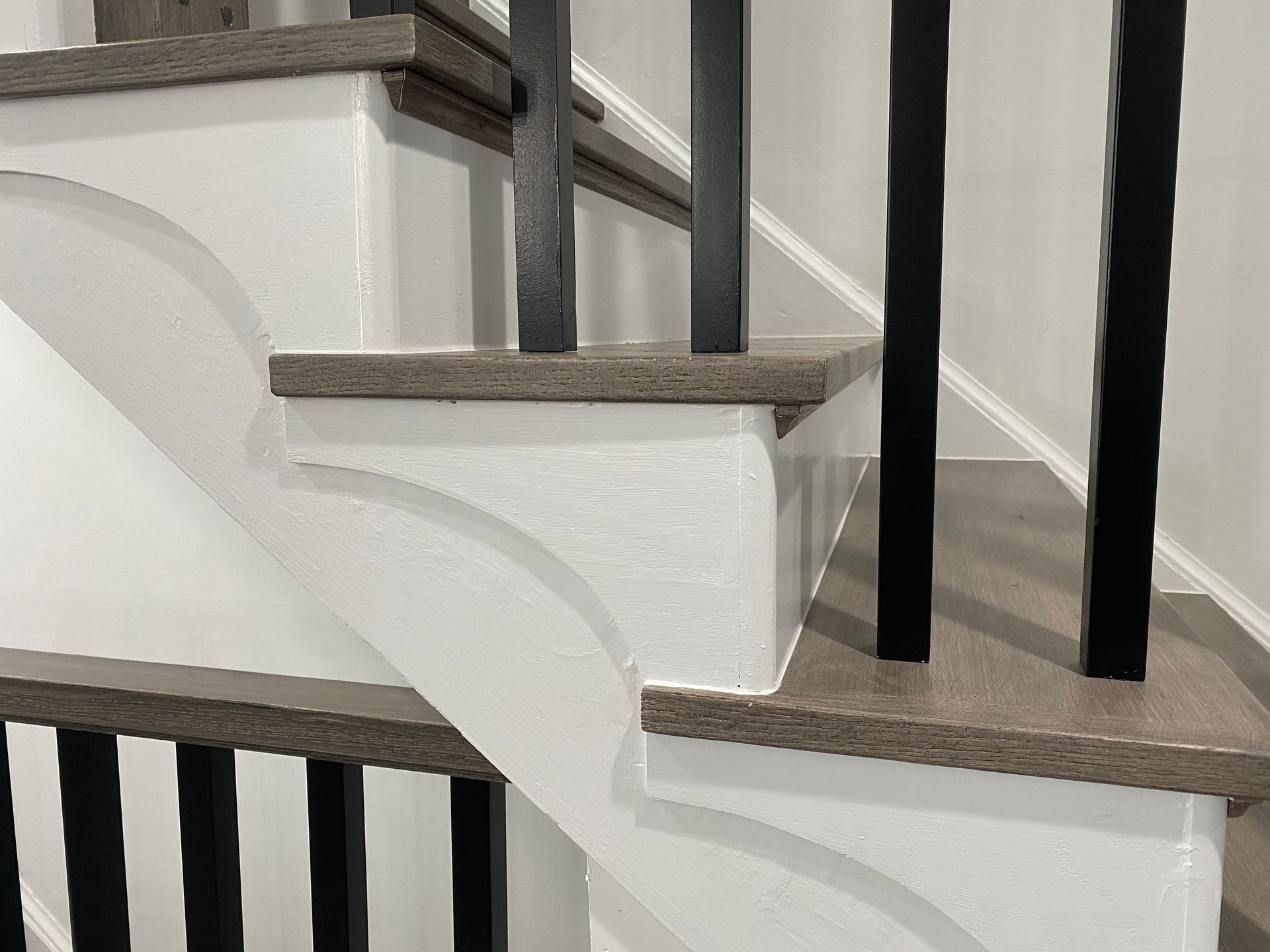 A close up of a staircase with a black railing.