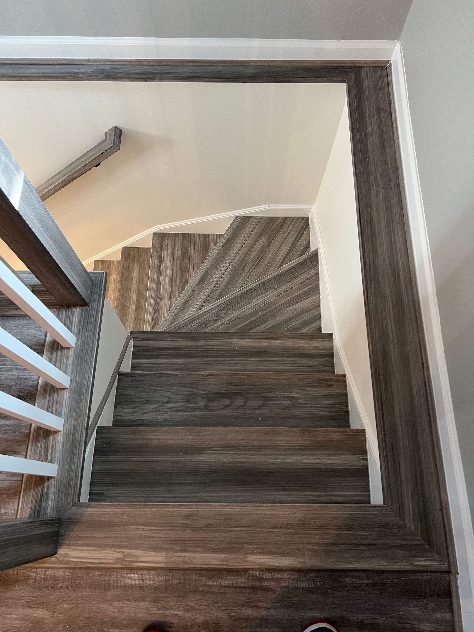 A staircase with wooden steps and a white railing in a house.