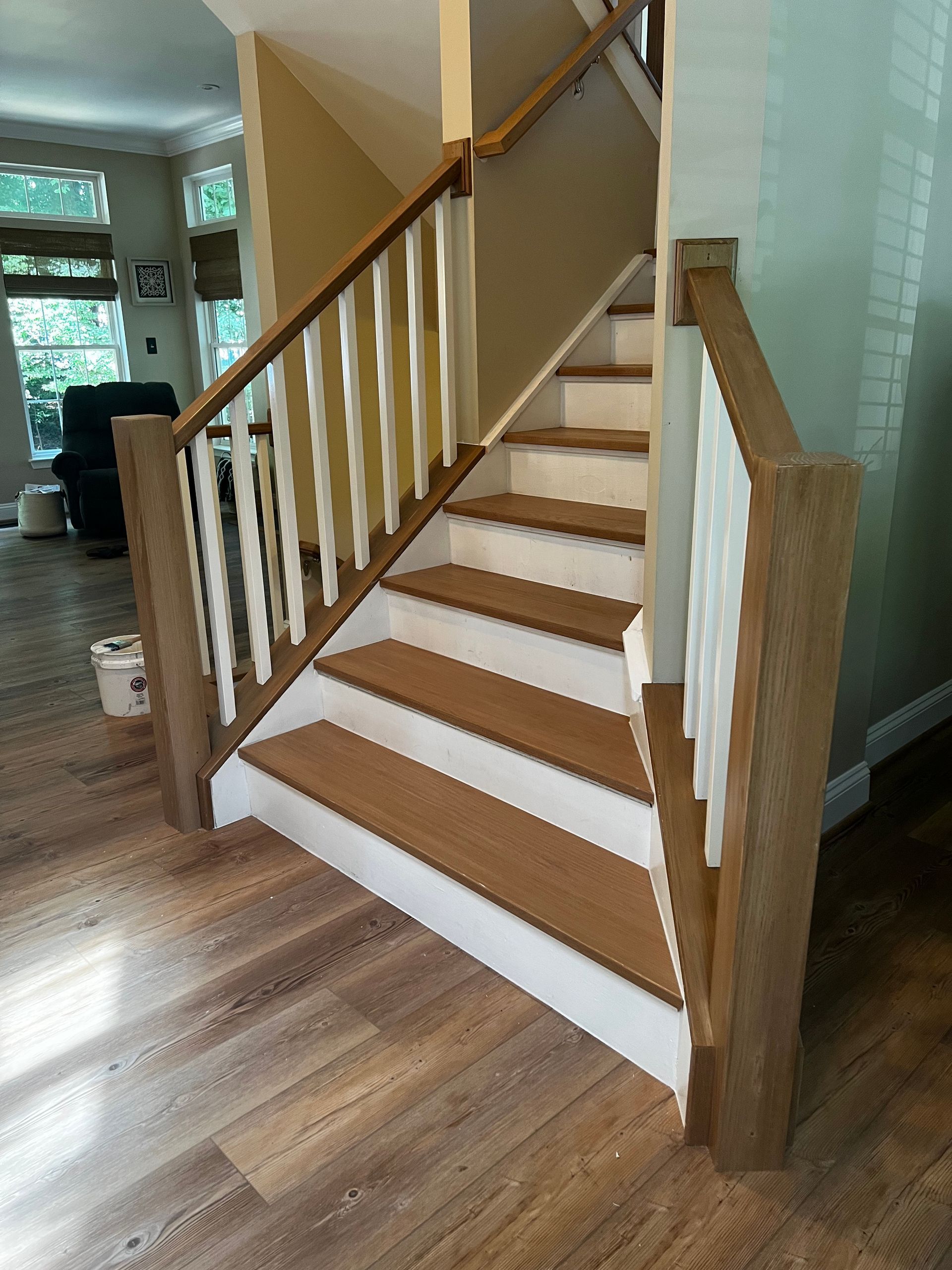 A staircase with wooden steps and white railing in a living room.