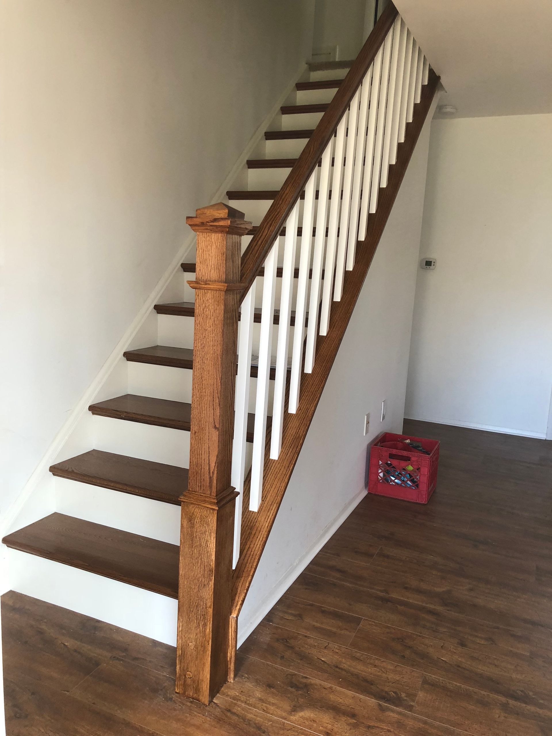 A wooden staircase with a white railing in a hallway.