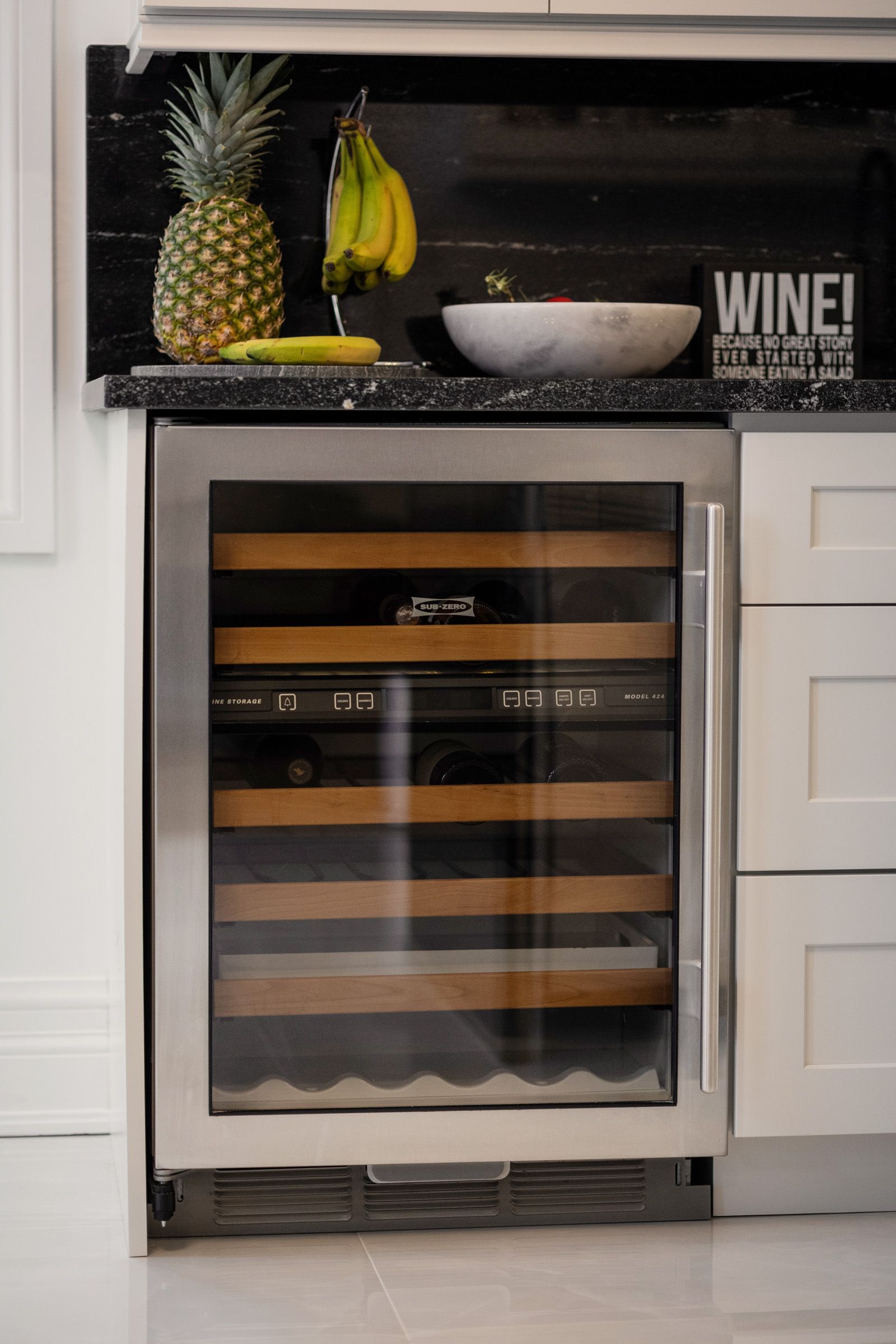 A kitchen with a wine cooler and a sign that says wine