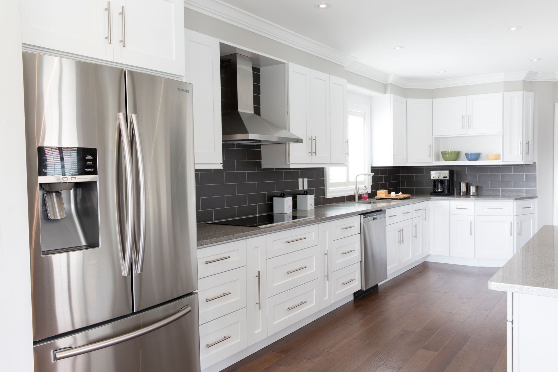 A kitchen with stainless steel appliances and white cabinets.