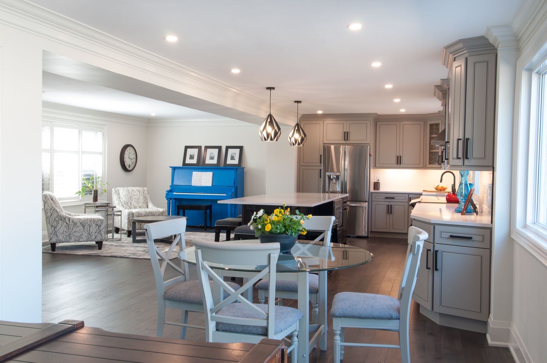 A kitchen with a blue piano and a table and chairs