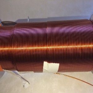 Coil of copper wire, tightly wound, with a gap exposing white material underneath