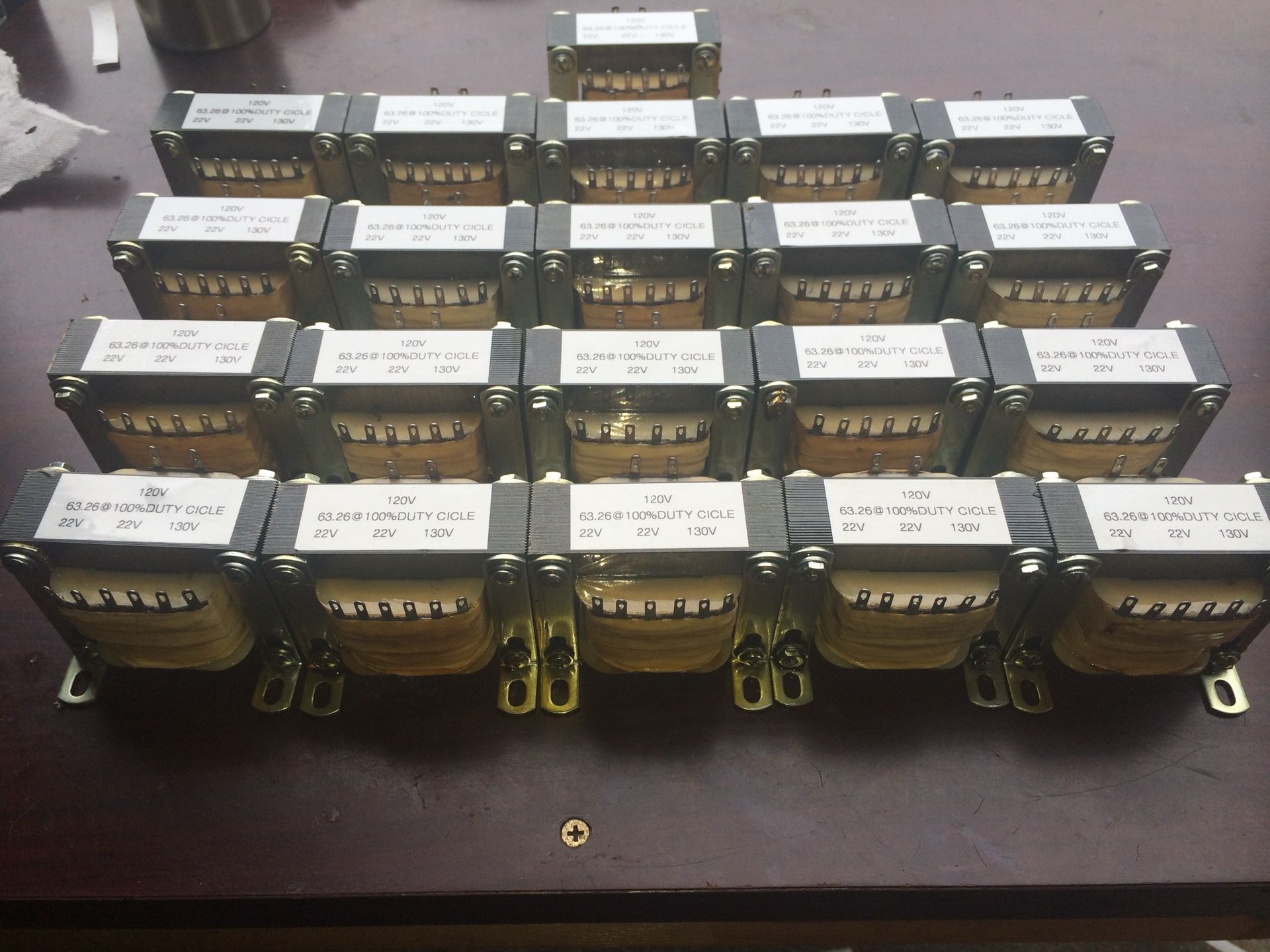 Close-up of a circuit board with copper coils, a fuse, and other electronic components