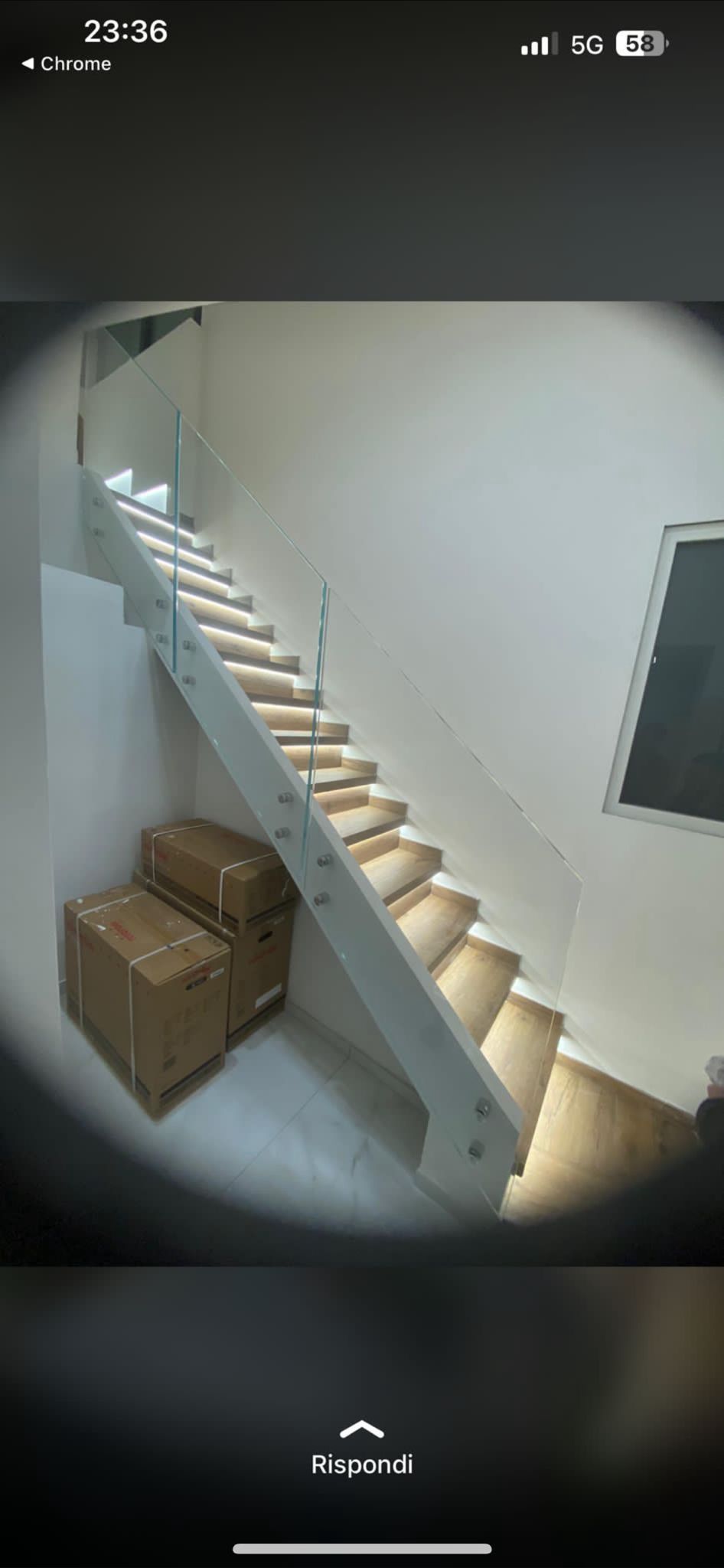 Una scala con luci integrate. In fondo ci sono due scatole di cartone.