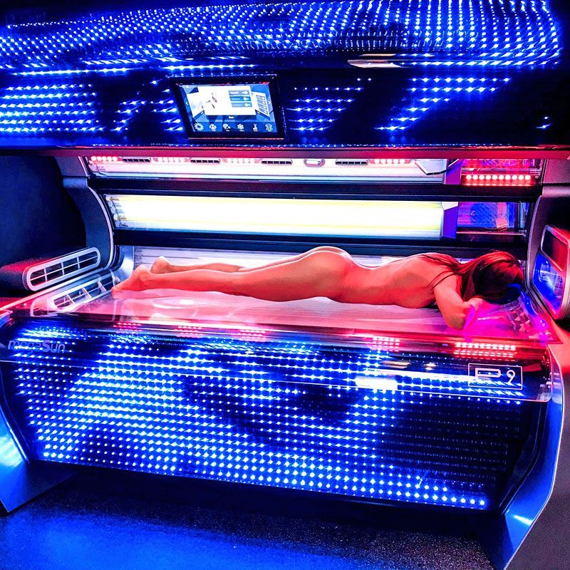 Frau liegt nackt auf bräunungsgerät