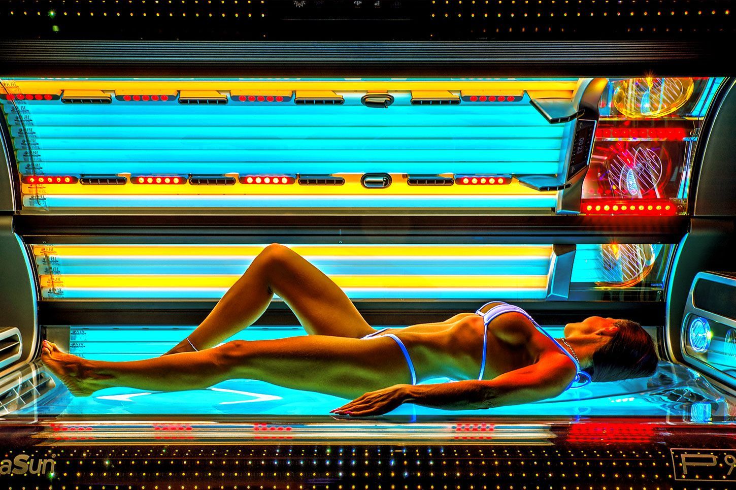 Eine Frau im Bikini liegt in einem Solarium