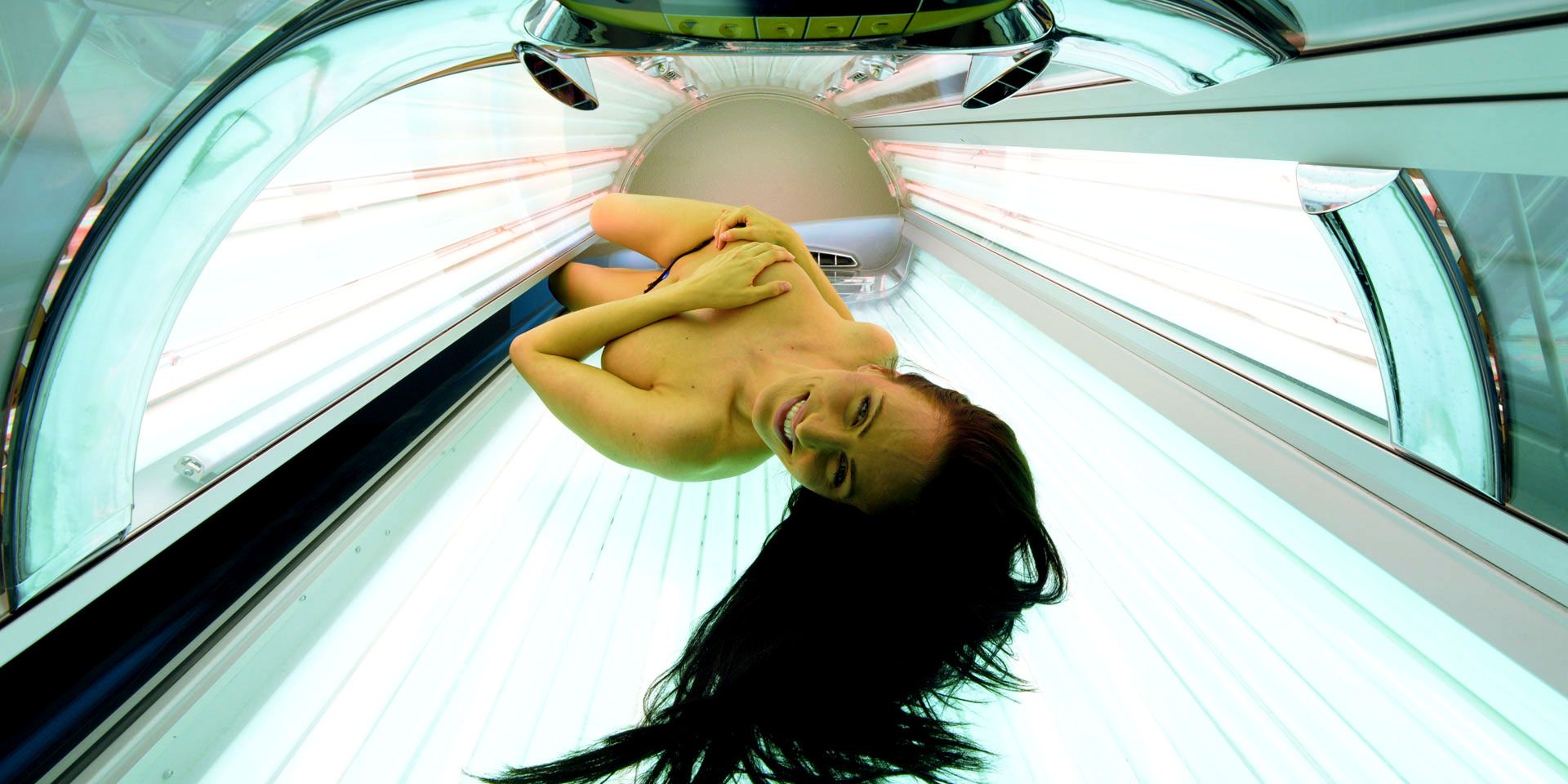 Eine Frau liegt kopfüber in einem Solarium