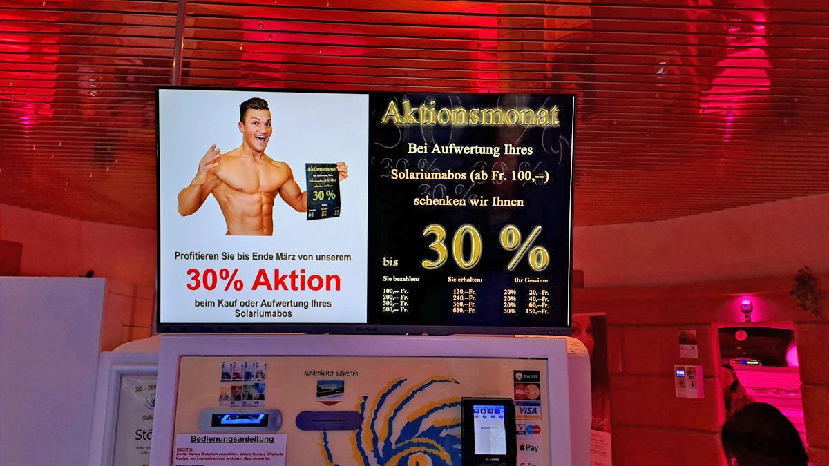 Großer Kundeninformationsbildschirm im SunWorld Solarium zeigt aktuelle Aktionen, Angebote, News und Hinweise direkt am Bezahlterminal.