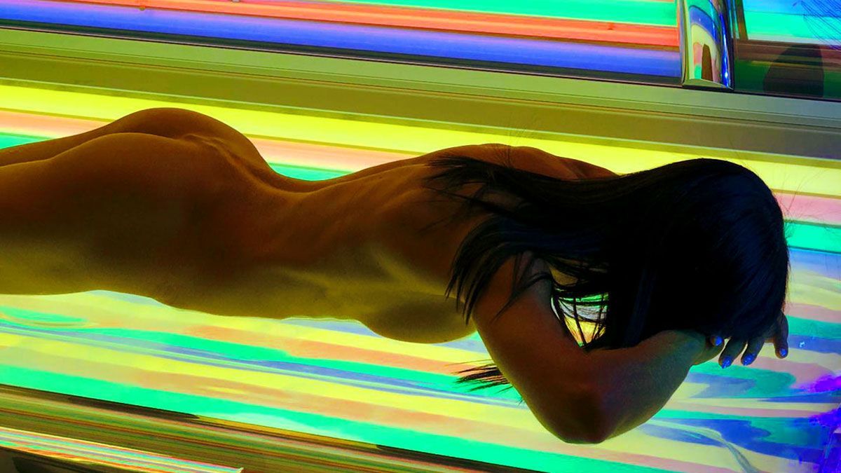 Eine Frau geniesst nackt das Rainbow licht im Solarium bei www.sunworld.ch.