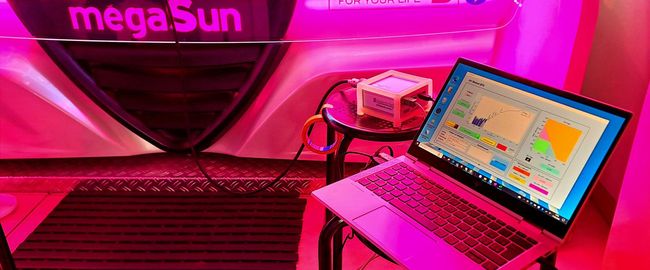 Laptop mit Messsoftware vor einem MegaSun Solarium bei SunWorld – garantiert gesetzeskonforme Sicherheit und geprüfte Strahlungswerte.