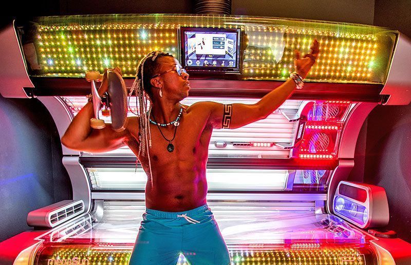 Stylischer Mann mit Skateboard vor dem P9 Solarium bei SunWorld – perfekte Vorbereitung auf den Sommer durch sicheres Vorbräunen und Vitamin D-Aufbau.