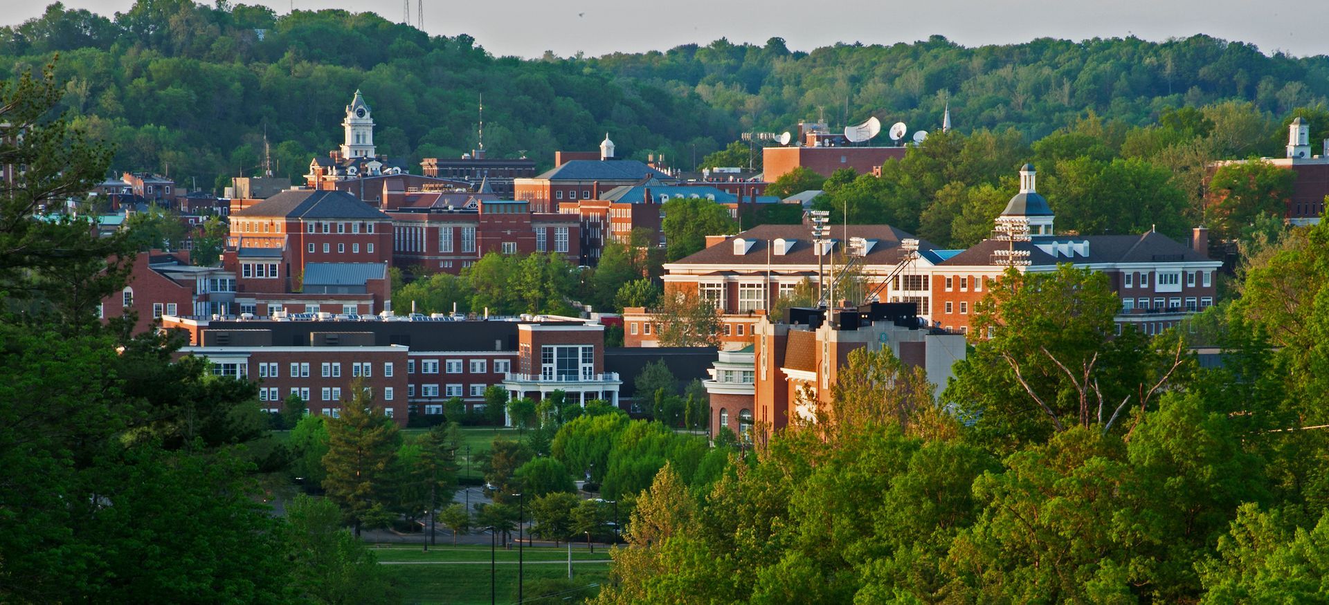 View of a college campus with red brick buildings and green trees. Athens County, OH