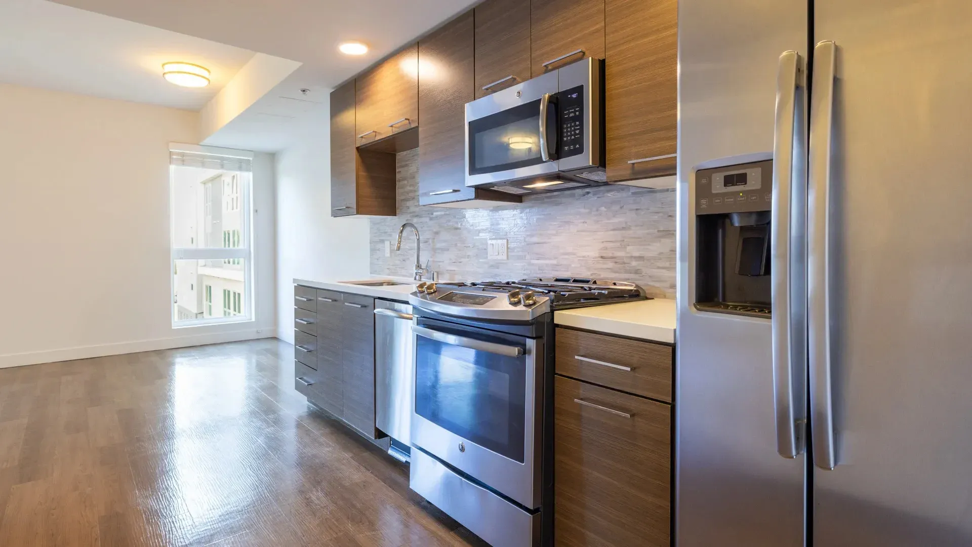 Modern kitchen with stainless steel appliances and wood cabinetry.