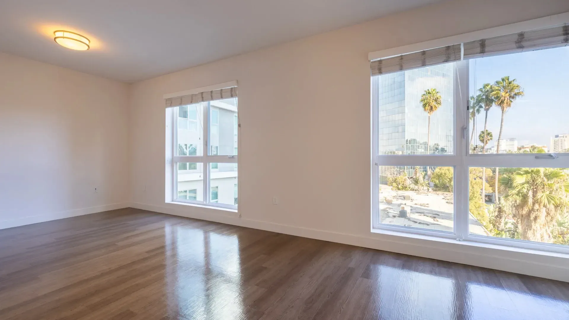 Empty apartment living room with large windows and city view