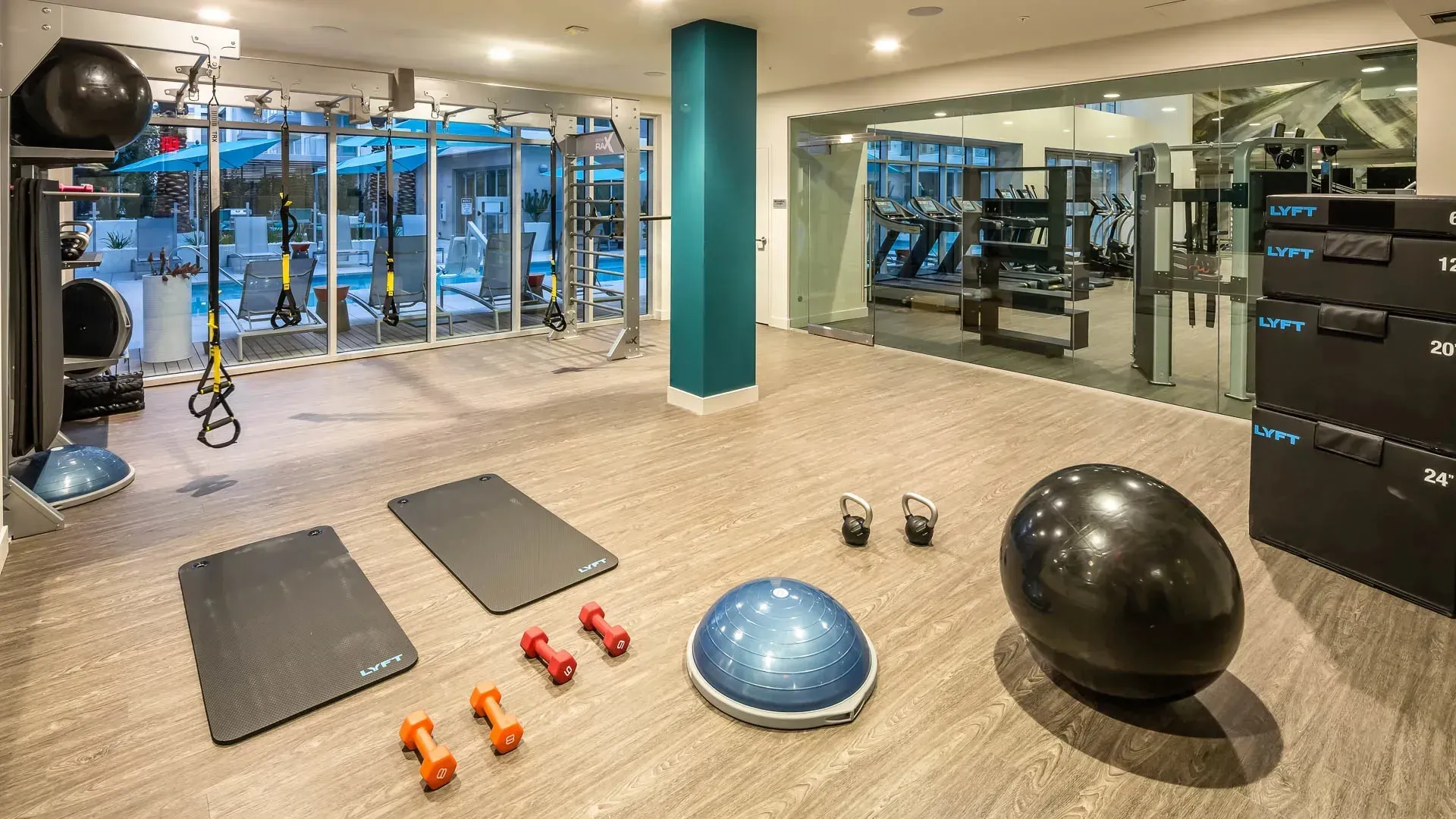 Gym with fitness equipment and view of the pool.
