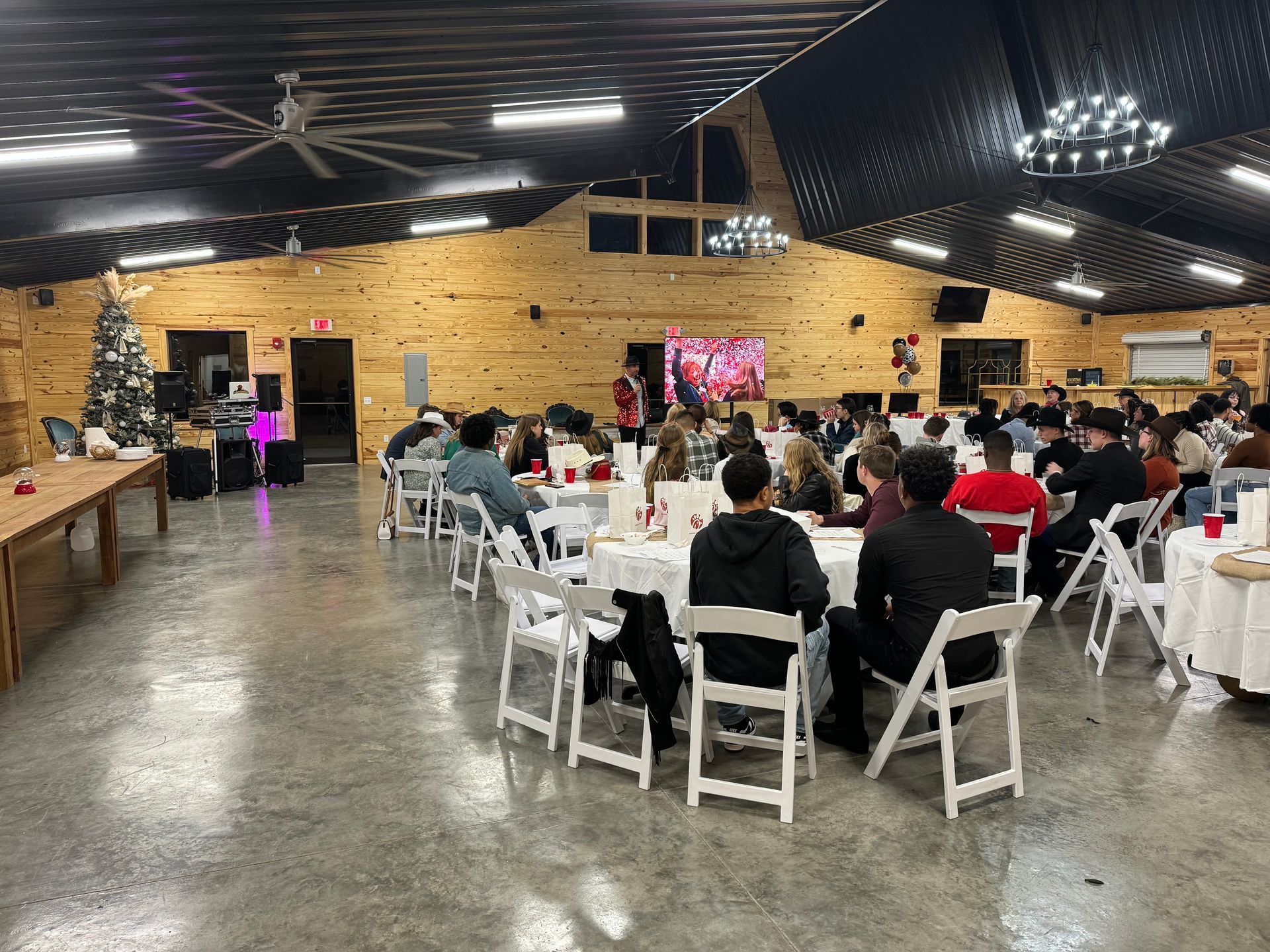 A large group of people are sitting at tables in a large room.