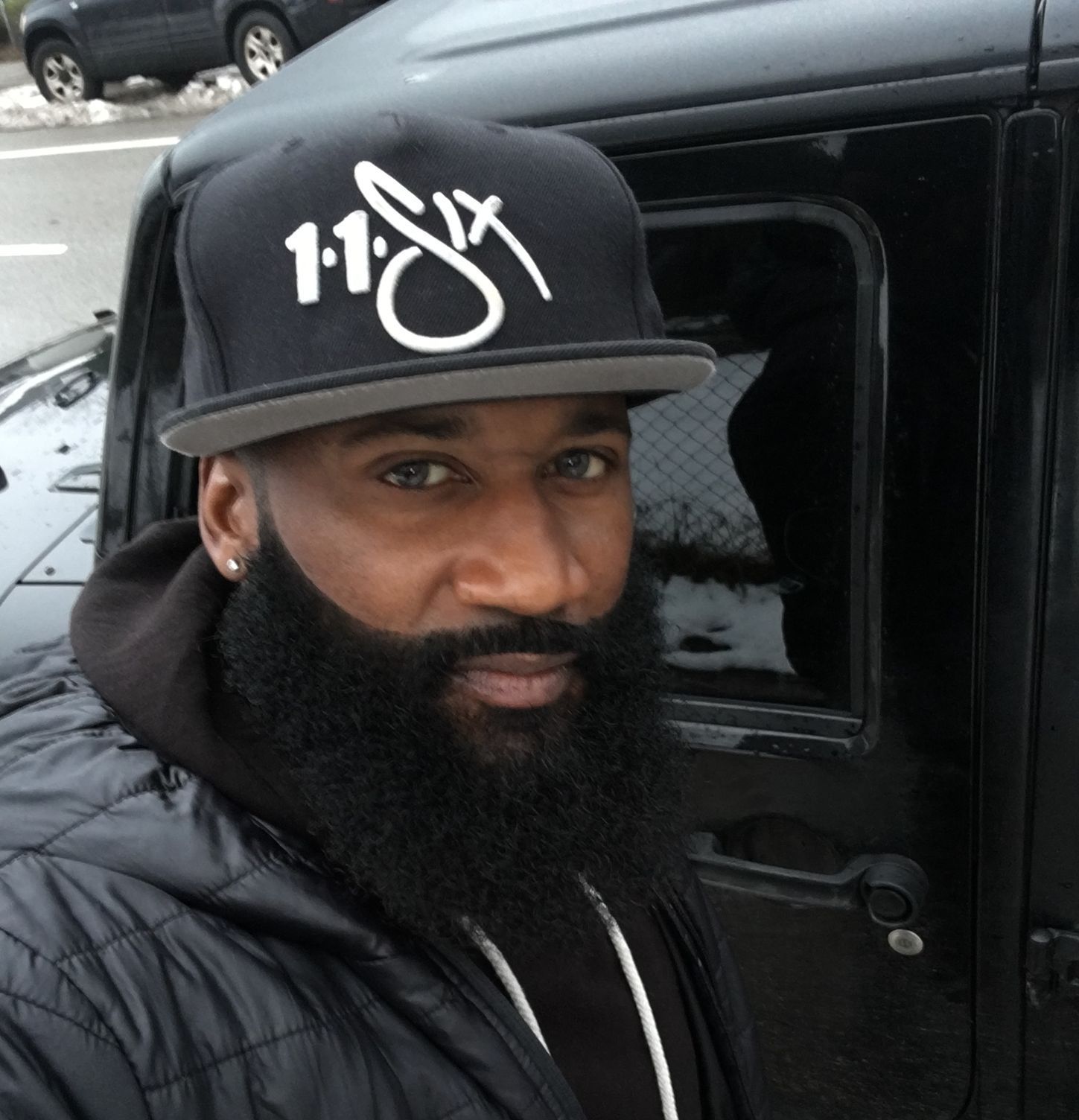 A man with a beard wearing a hat that says 11 six
