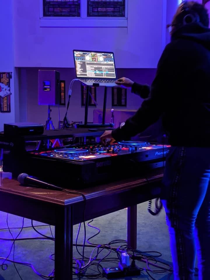 A person is standing at a table with a laptop on it