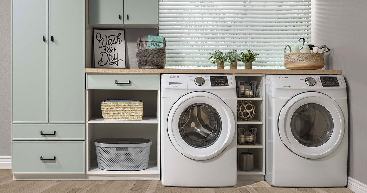 A laundry room with two washing machines and a dryer.