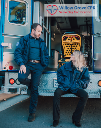 a man and a woman are sitting in front of an ambulance .