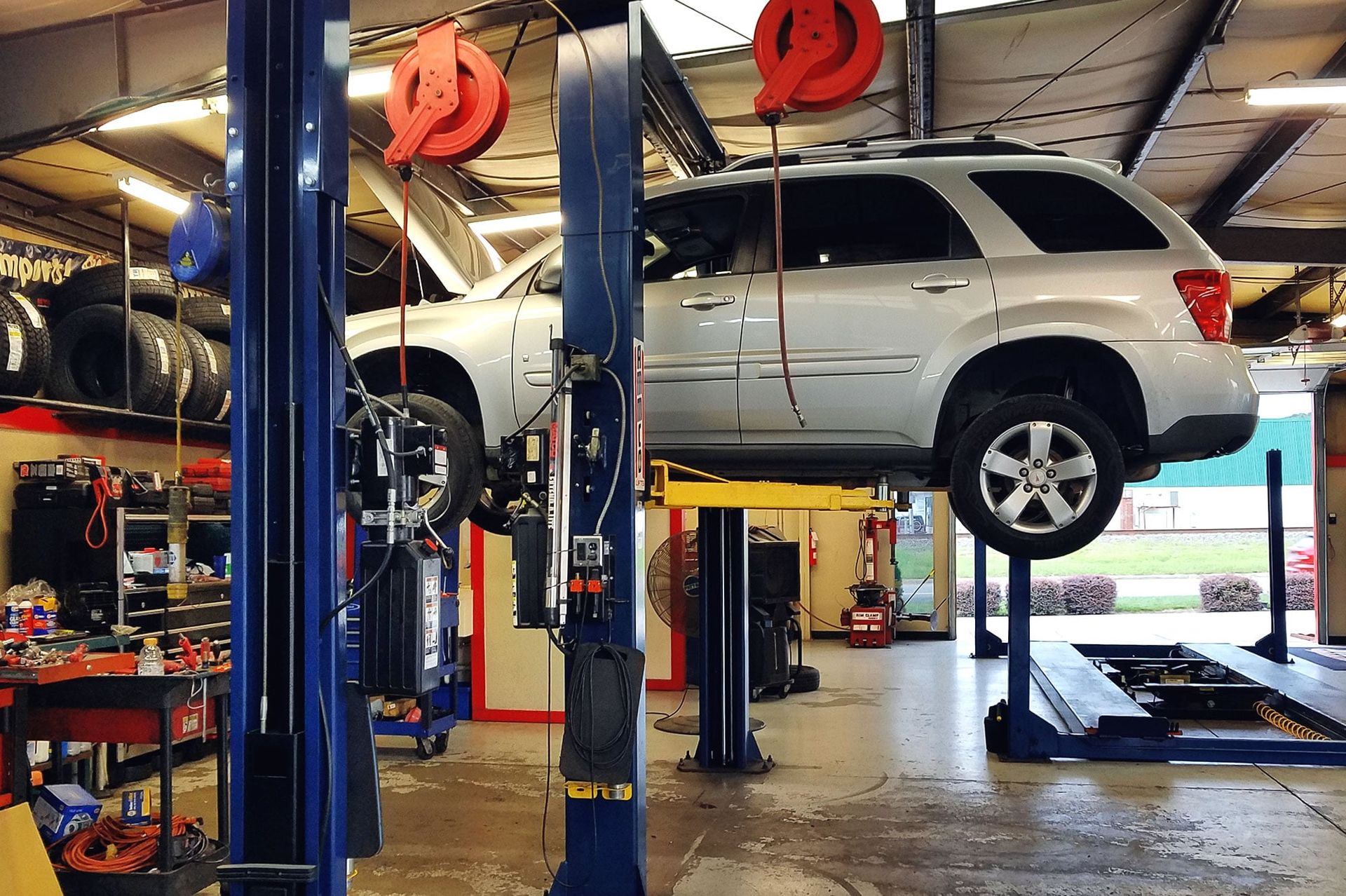 A car is sitting on a lift in a garage.