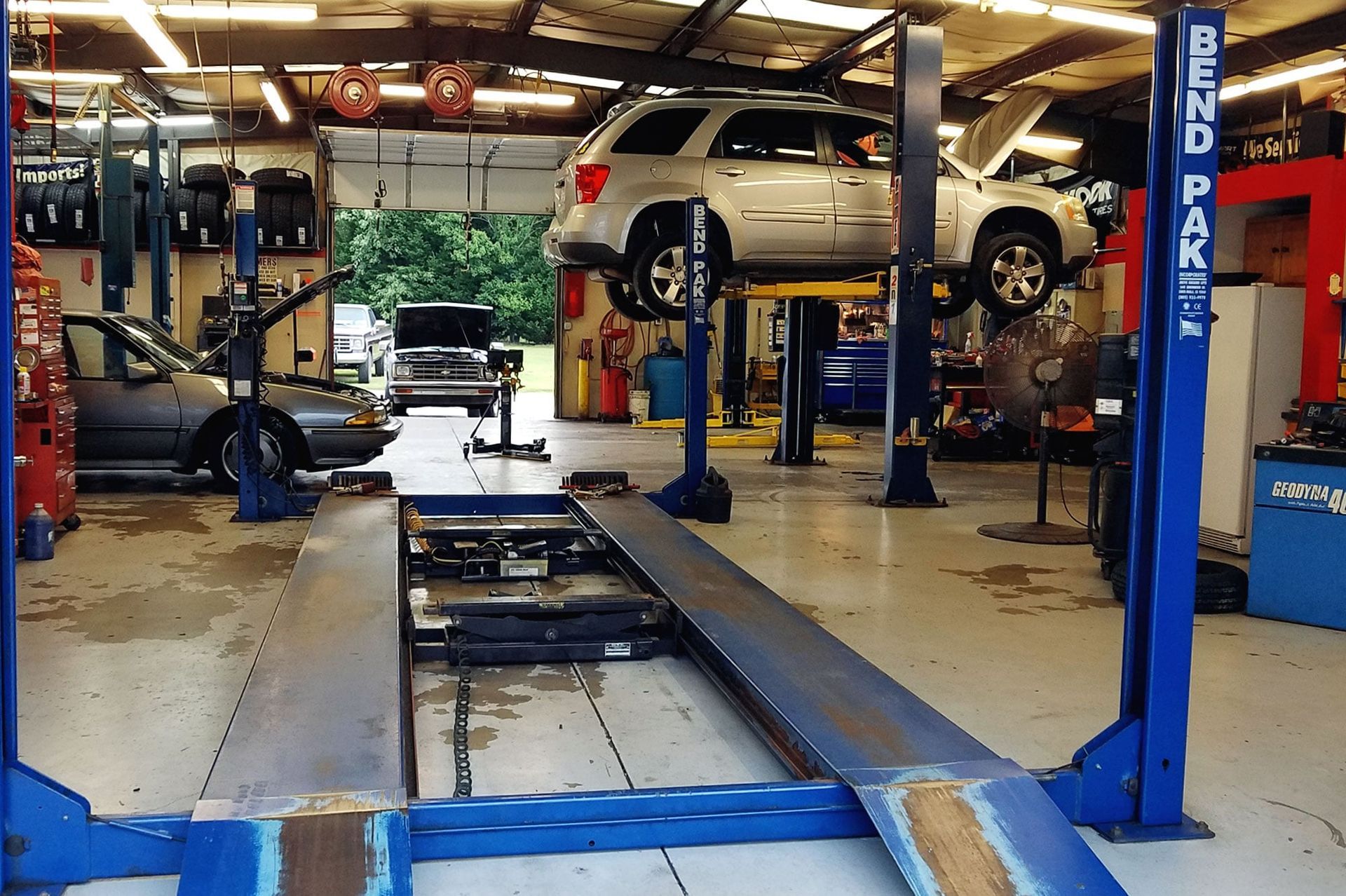 A car on a lift in a garage that says bend park
