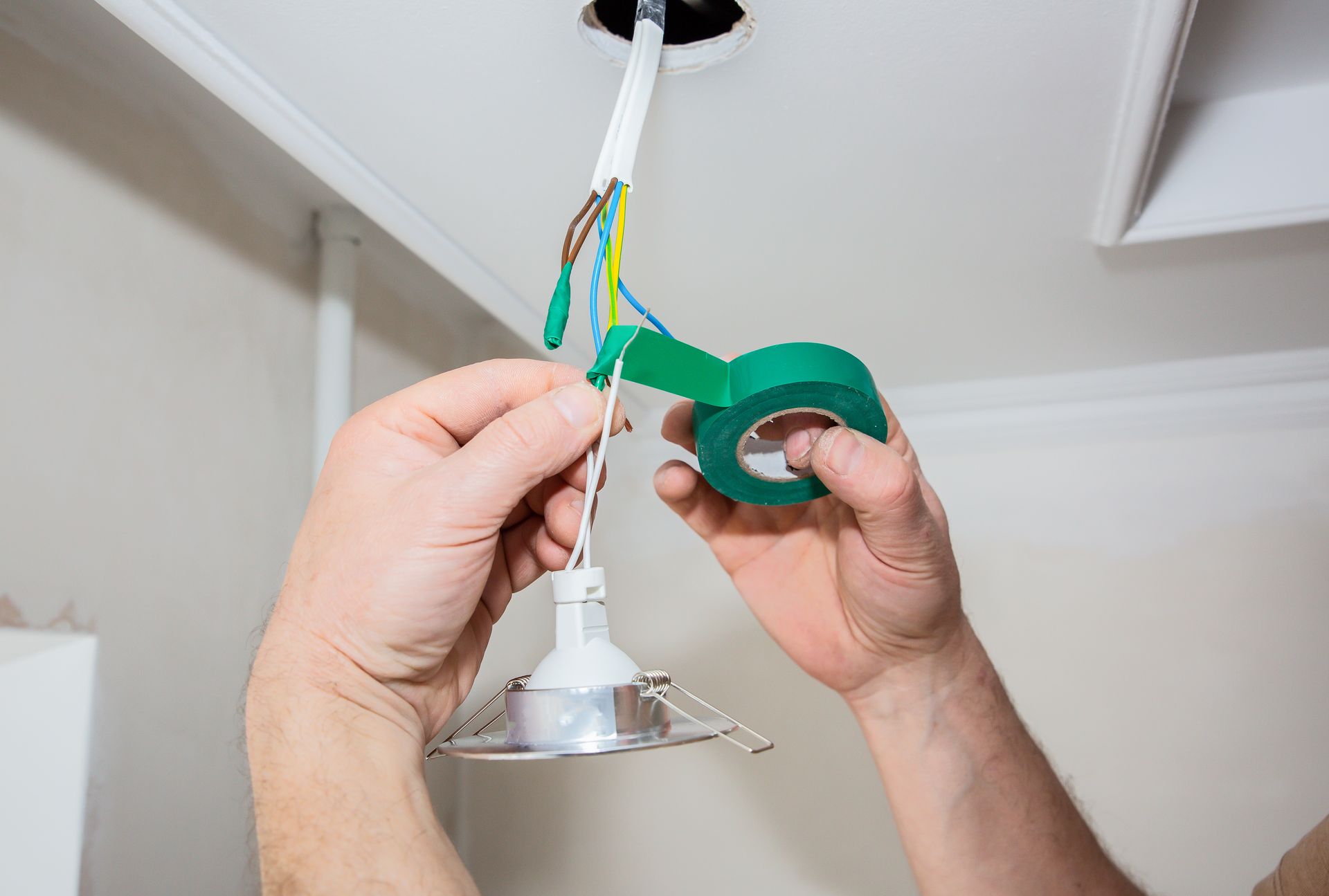 holding adhesive tape to insulate light bulb