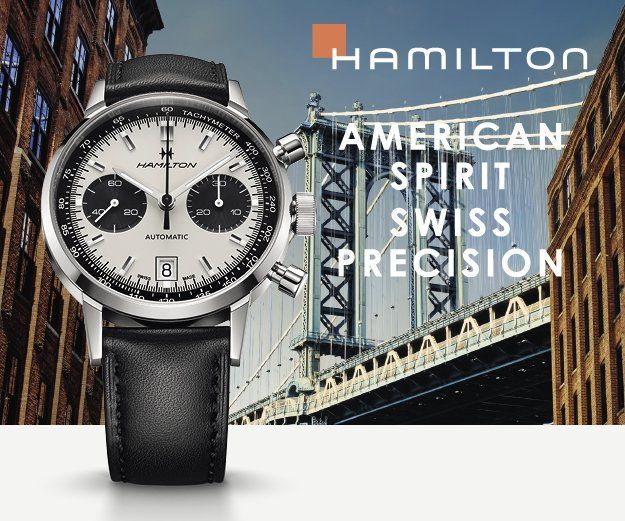 Pubblicità di un orologio Hamilton con cronografo argentato e cinturino in pelle nera sullo sfondo di un ponte cittadino.