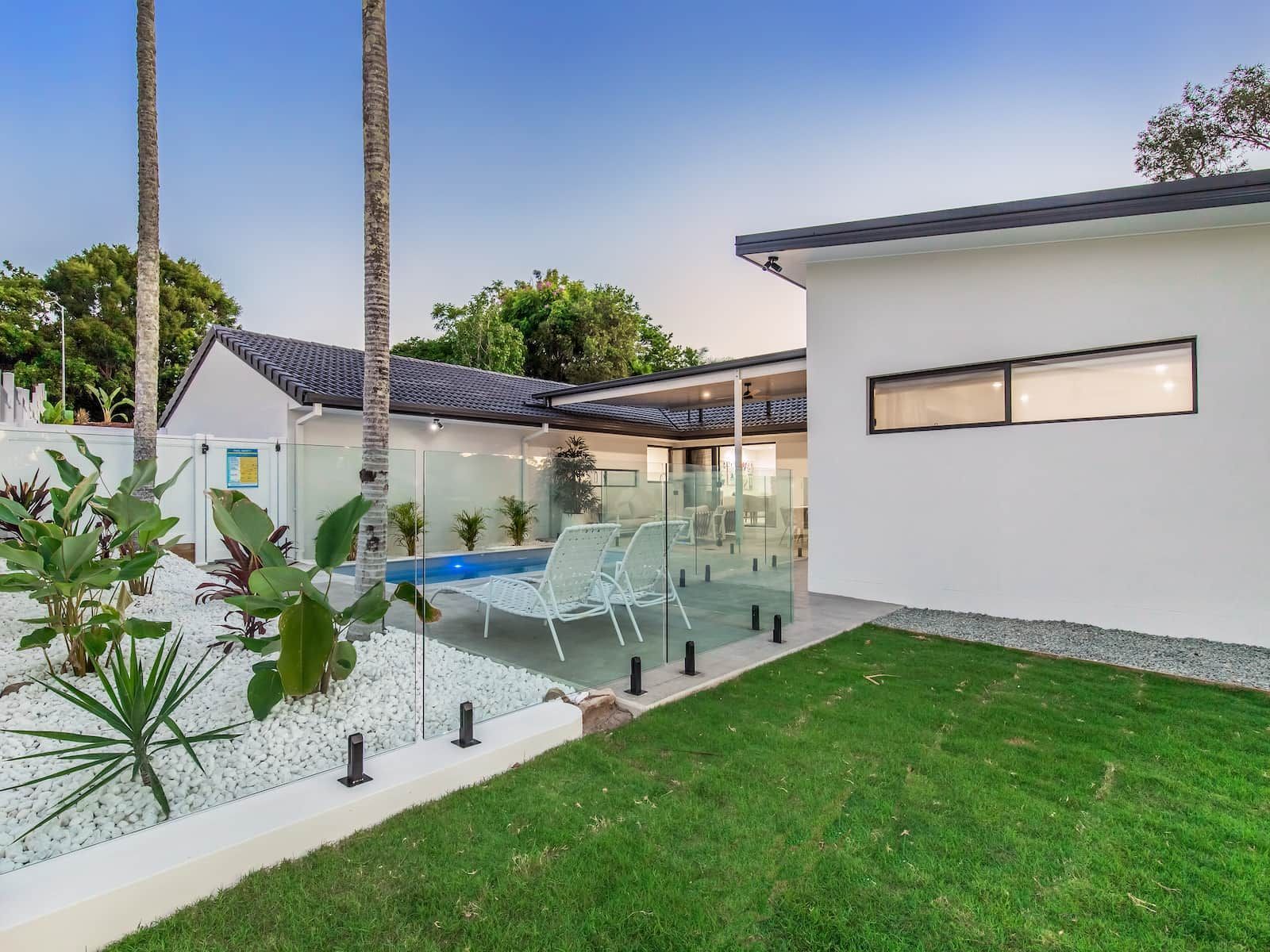 A white house with a swimming pool in the backyard