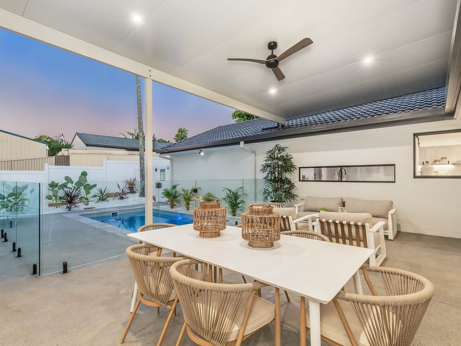 A patio with a table and chairs and a ceiling fan.