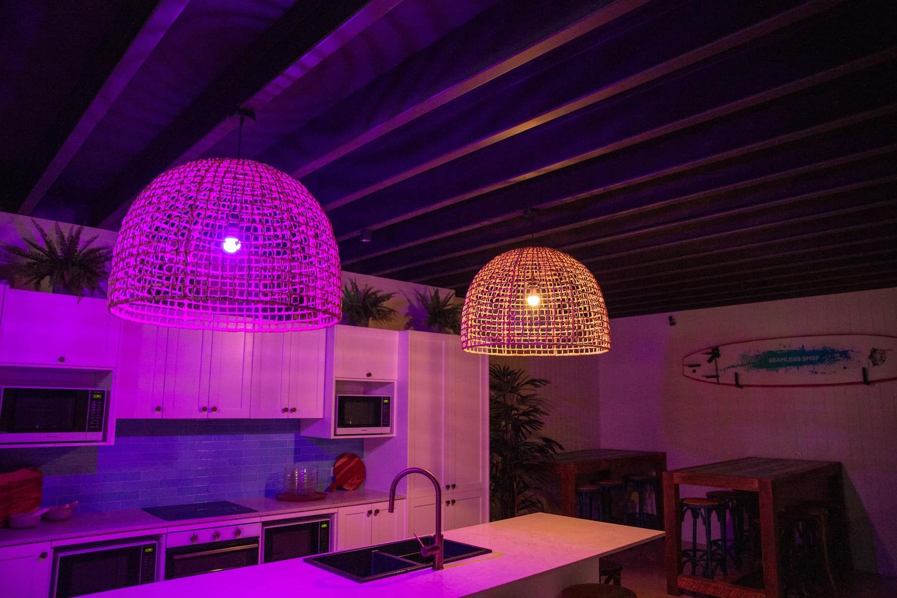 a kitchen with purple lights hanging from the ceiling.