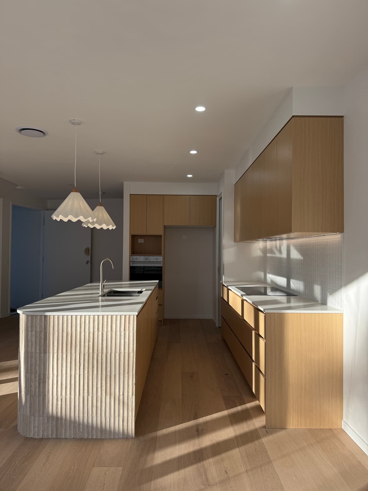 A kitchen with white cabinets , a sink and a refrigerator.