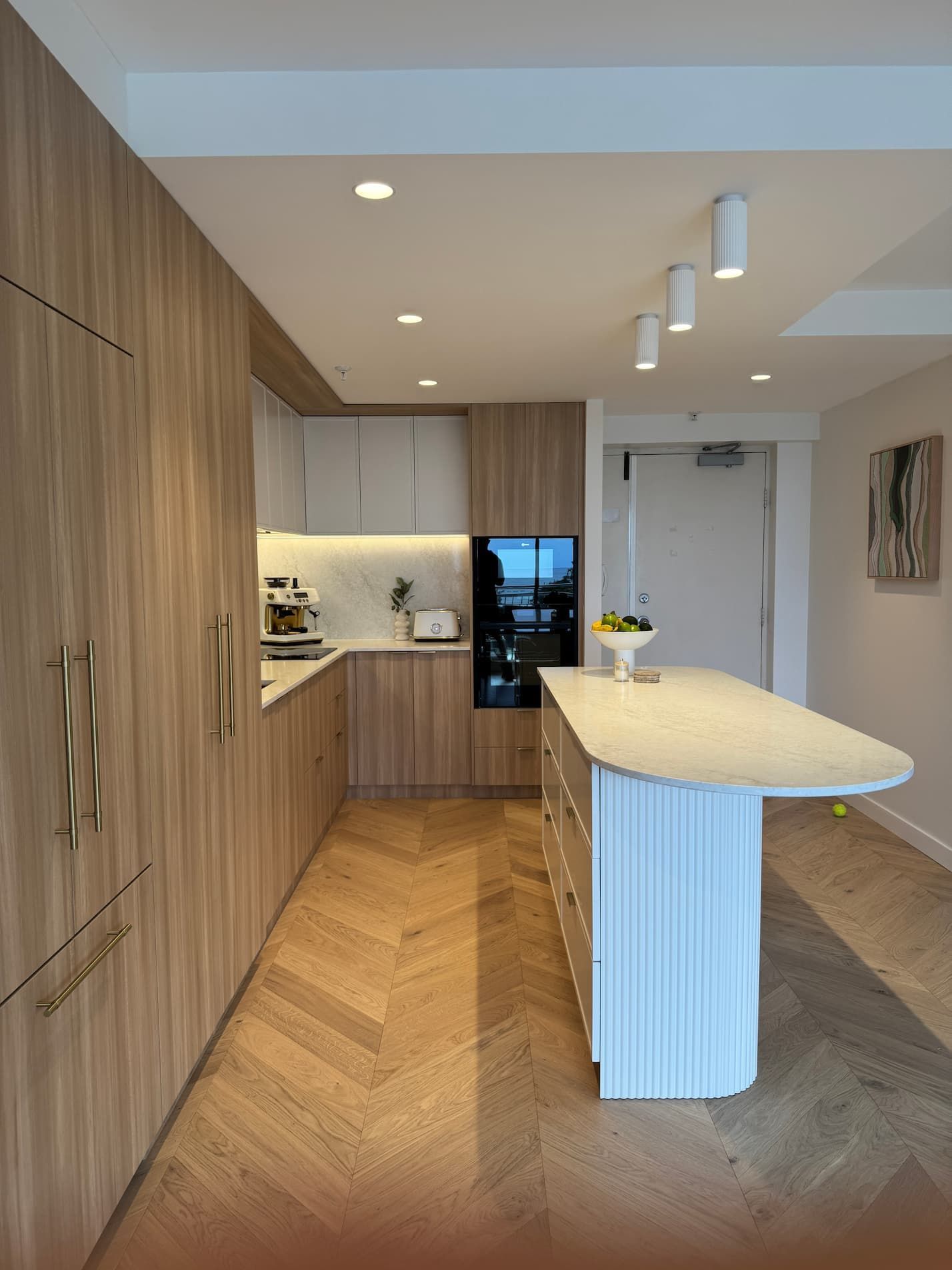 A kitchen with white cabinets , a sink and a refrigerator.