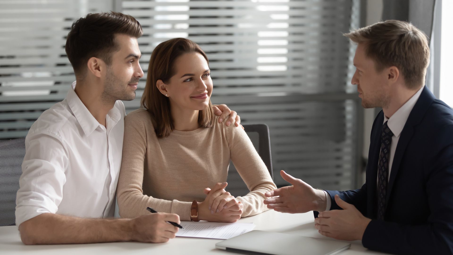 Picture of an insurance agent and two clients at an office discussing coverage options Picture of an insurance agent and two clients at an office discussing coverage options
