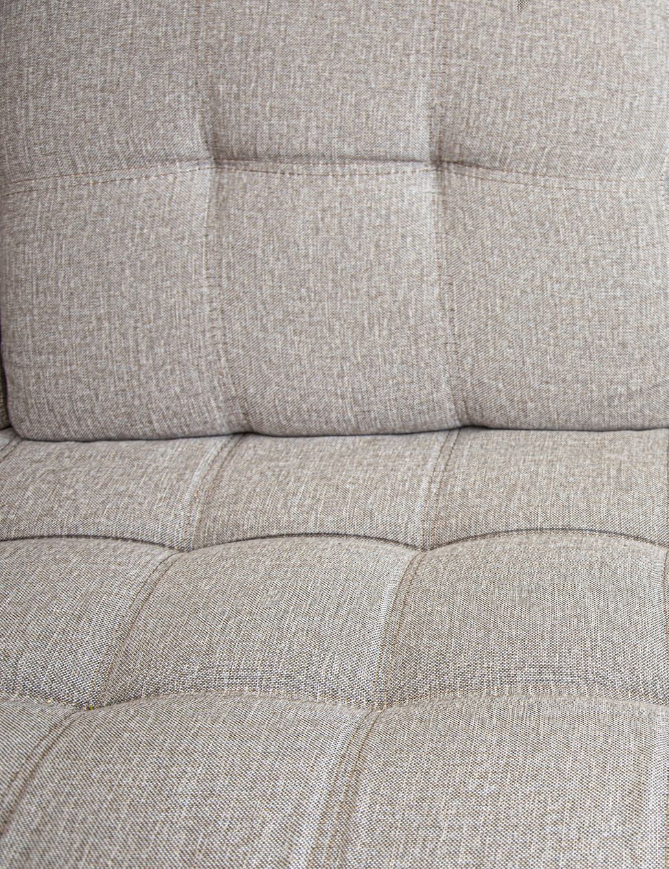 A close up of the back of a beige couch.