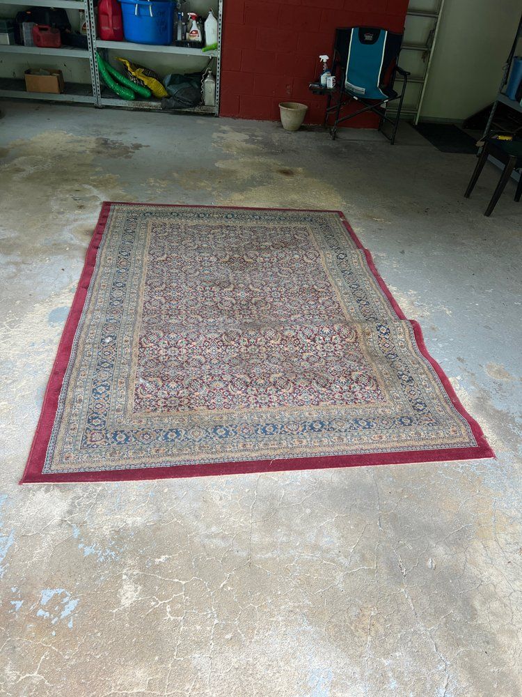 A rug is sitting on the floor in a garage.