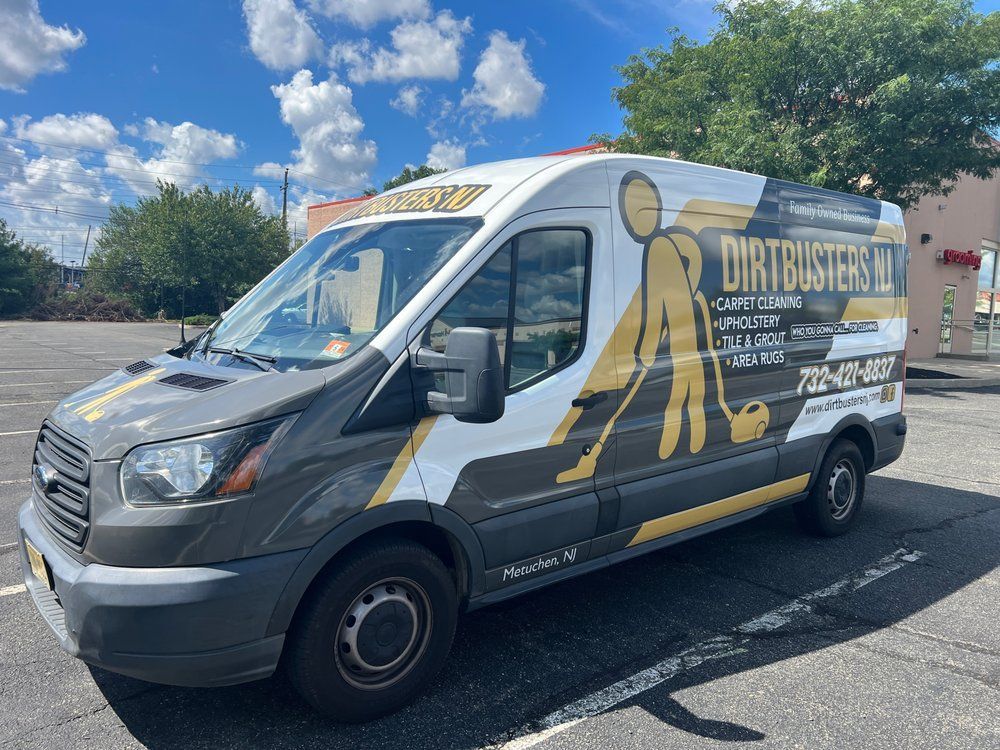 A dirtybusters van is parked in a parking lot.