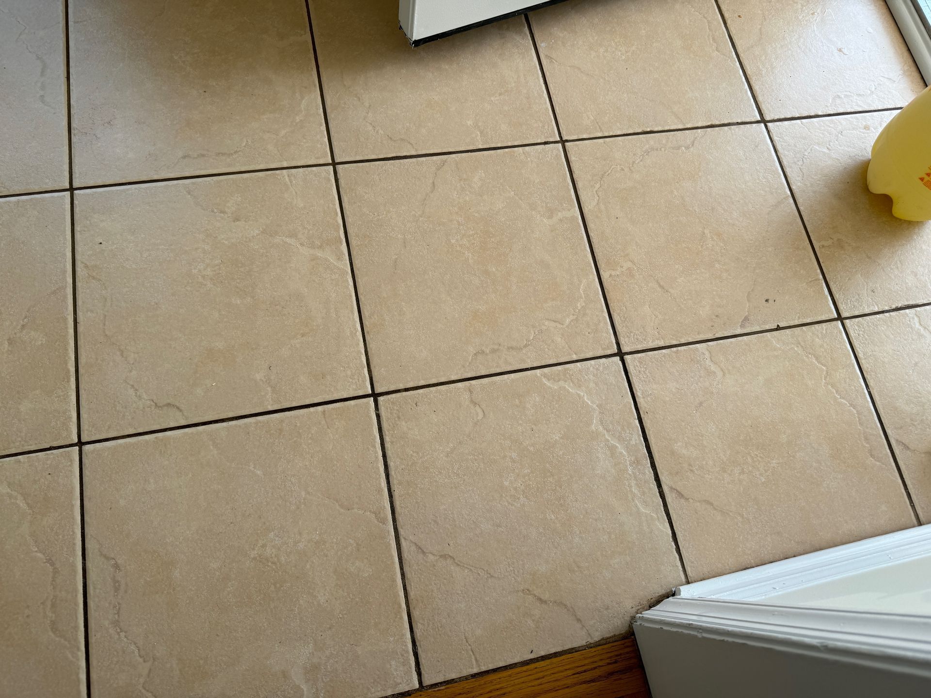 A close up of a tiled floor with a yellow line between the tiles.