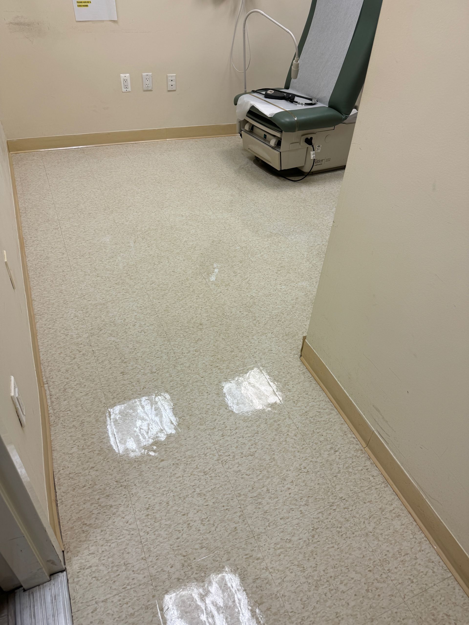 A doctor 's office with a chair and a light on the floor.