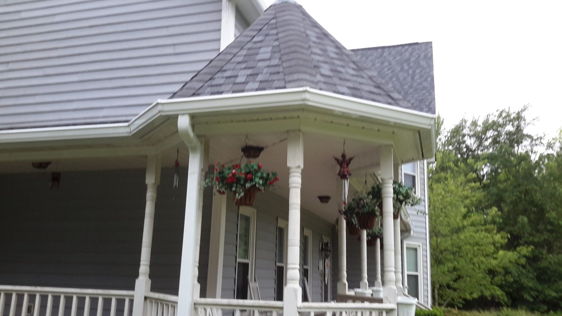Beige house with a white garage door and cobblestone driveway. A small dormer with windows is above the garage.